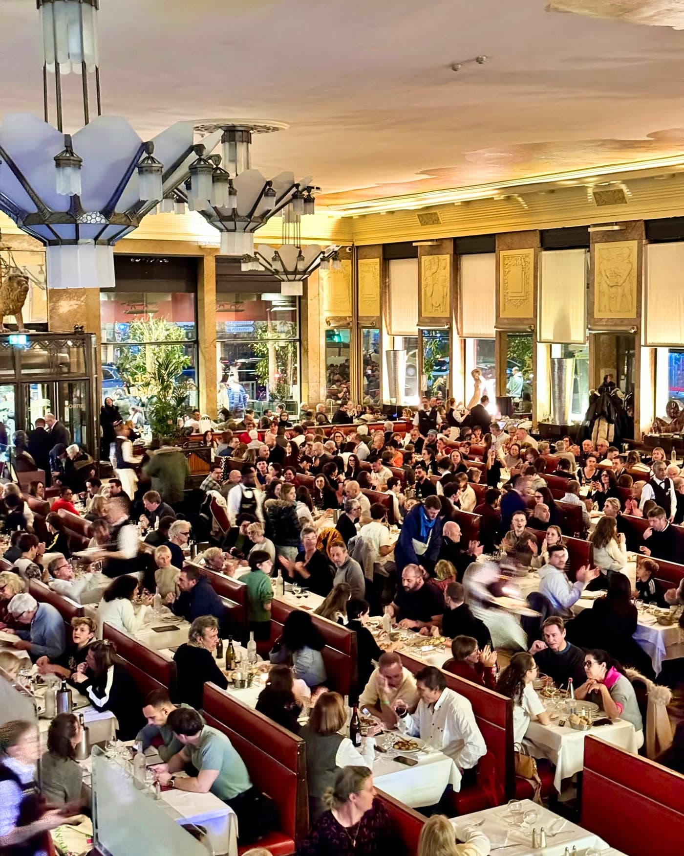 Vue plongeante depuis la mezzanine sur la salle bondée, lustres Art déco — Brasserie Georges