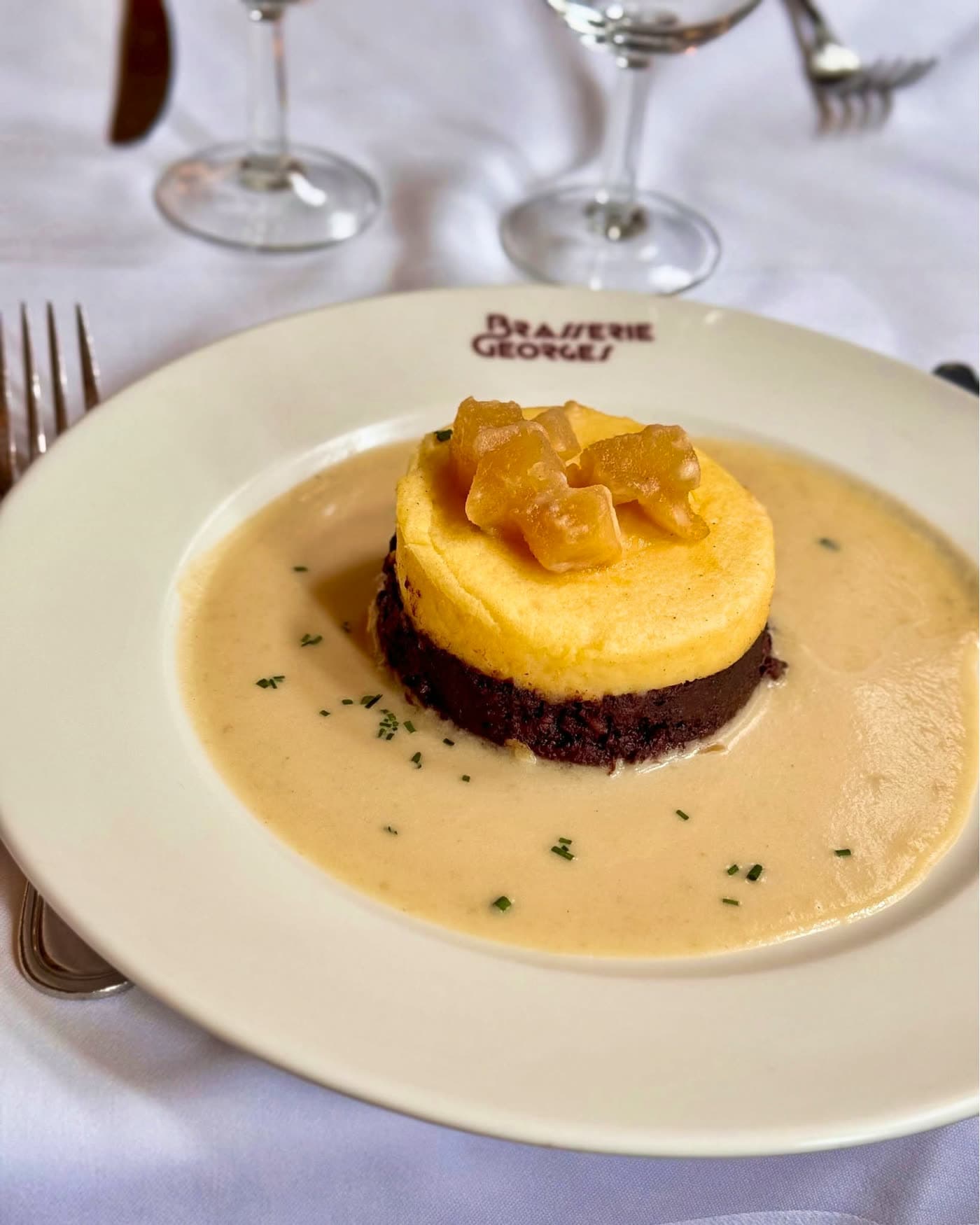 Gâteau de polenta et fond chocolat garni de compotée d'ananas sur assiette blanche — Brasserie Georges