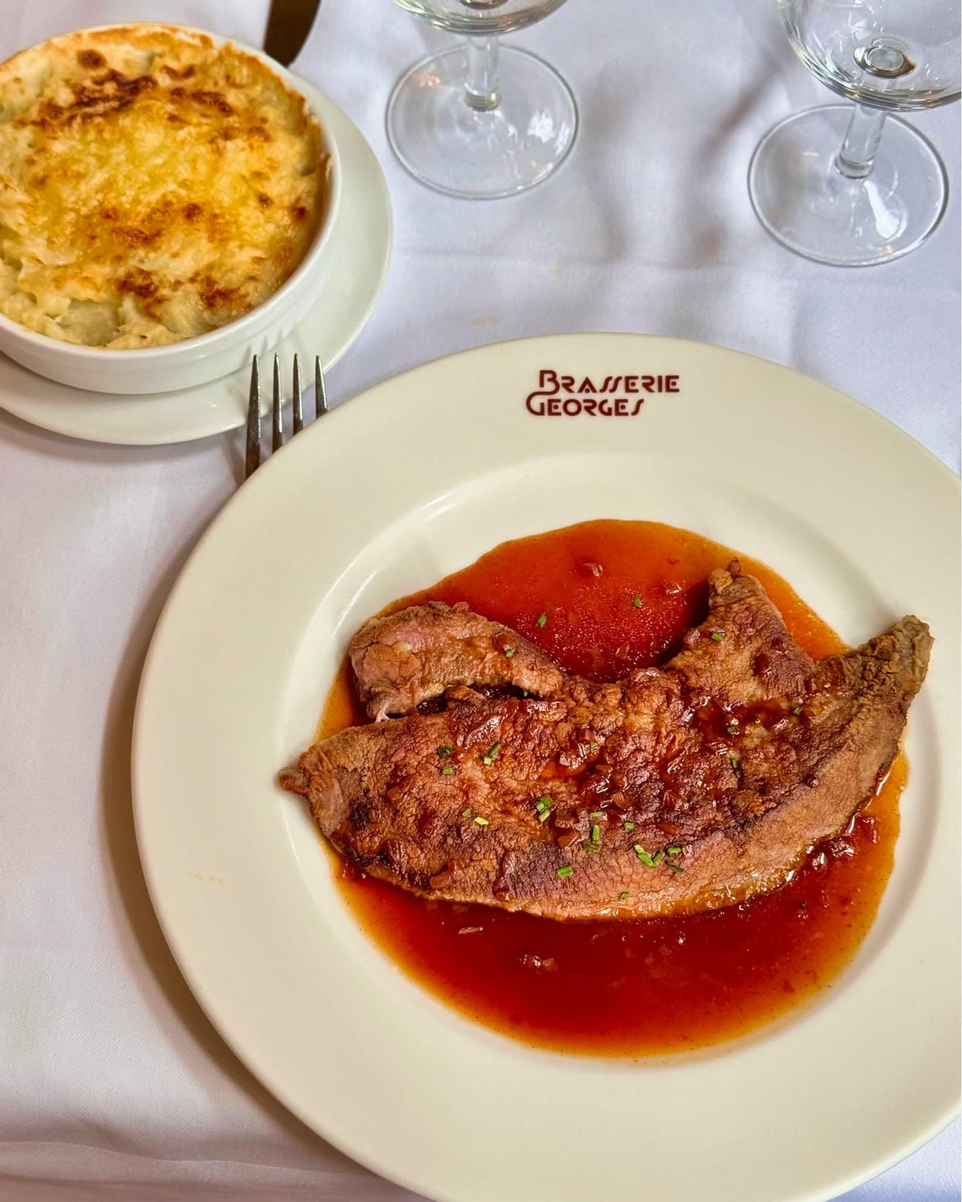 Pièce de viande sauce tomate accompagnée d'un gratin dauphinois — Brasserie Georges