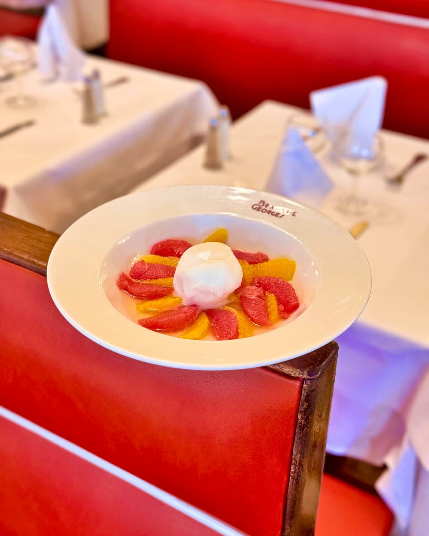 Salade d'agrumes colorée surmontée d'une boule de sorbet ou meringue — Brasserie Georges