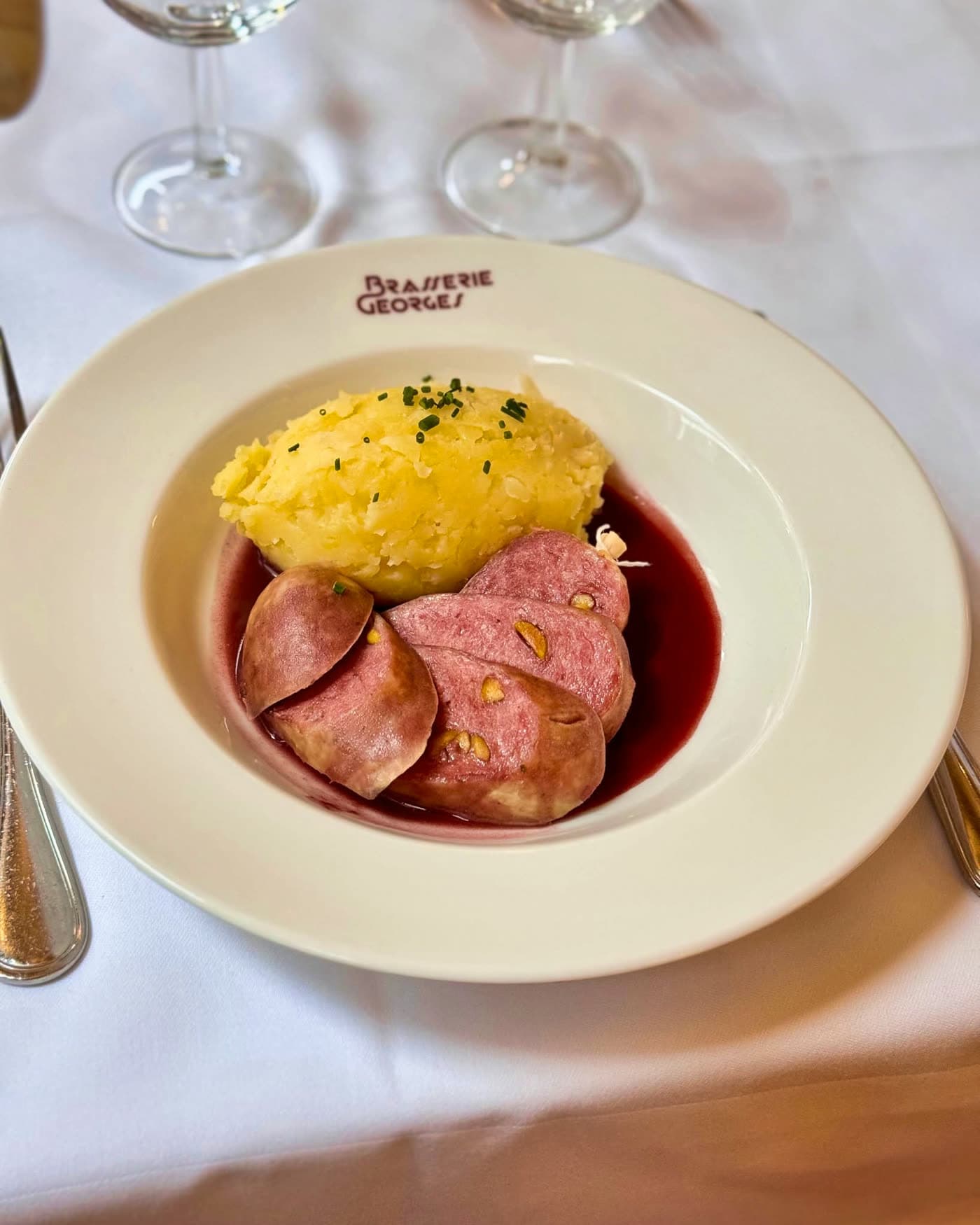 Cervelas pistaché tranché avec purée de pommes de terre et sauce au vin rouge — Brasserie Georges