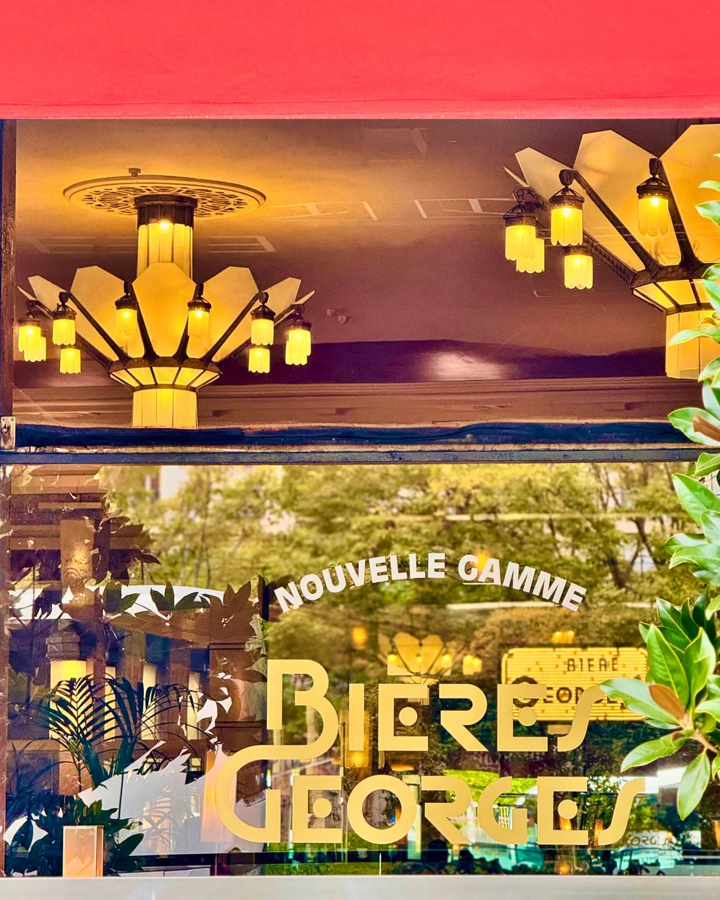 Vitrine avec inscription dorée Bières Georges et reflet de lustres Art déco — Brasserie Georges