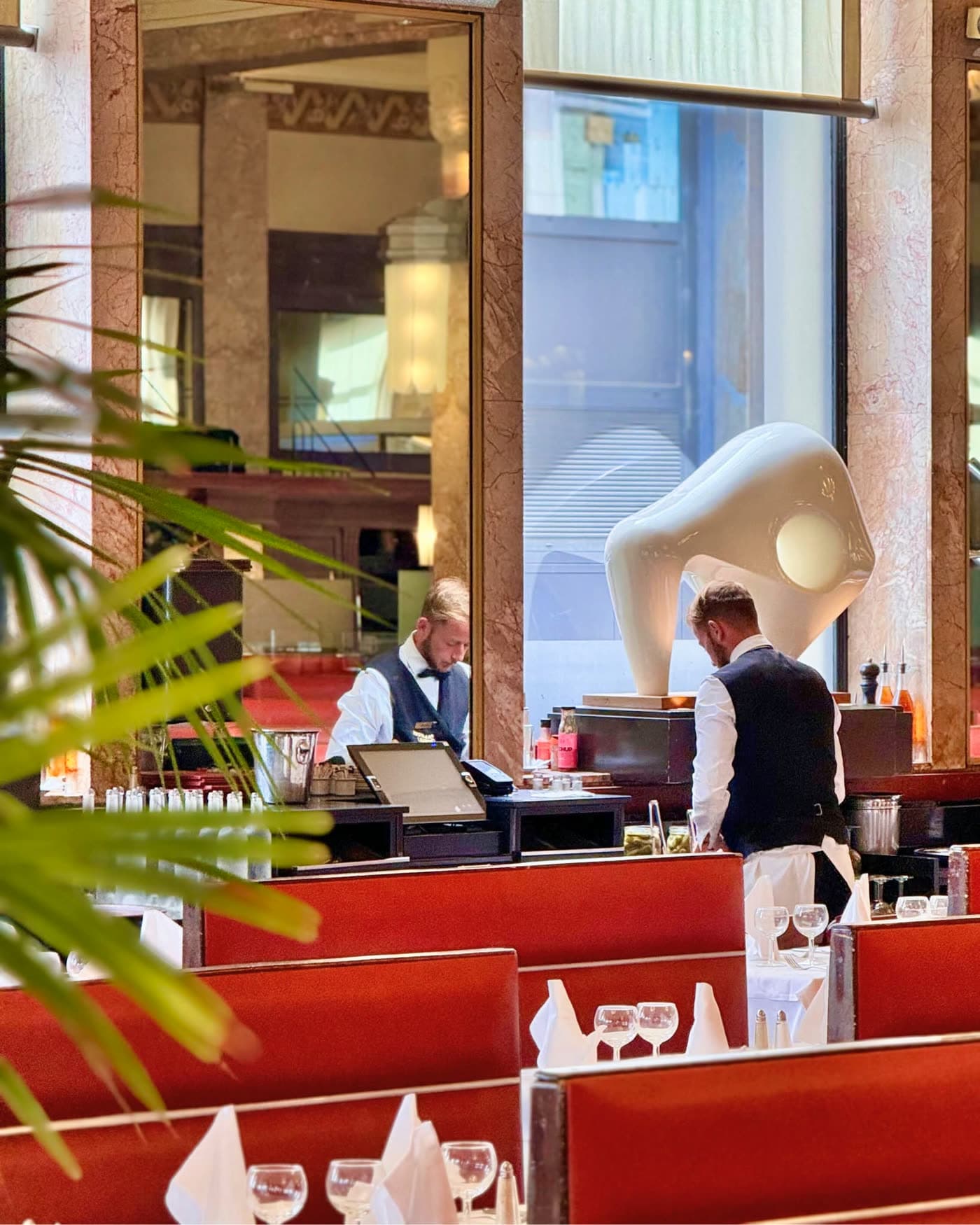 Reflet dans miroir d'un comptoir de service avec sculpture blanche design et personnel — Brasserie Georges