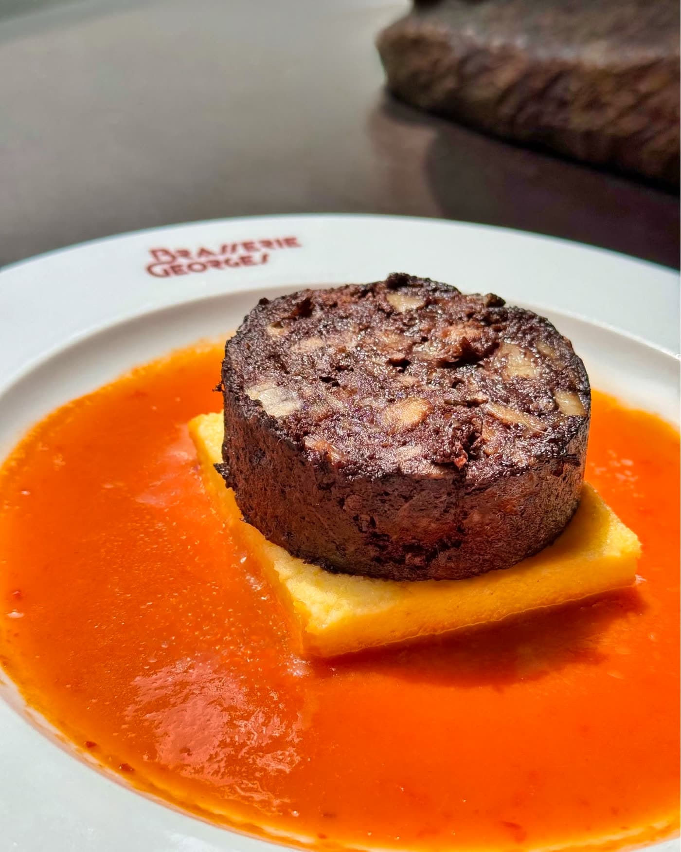 Pâté en croûte sur lit de polenta nappé de sauce tomate orangée, gros plan — Brasserie Georges