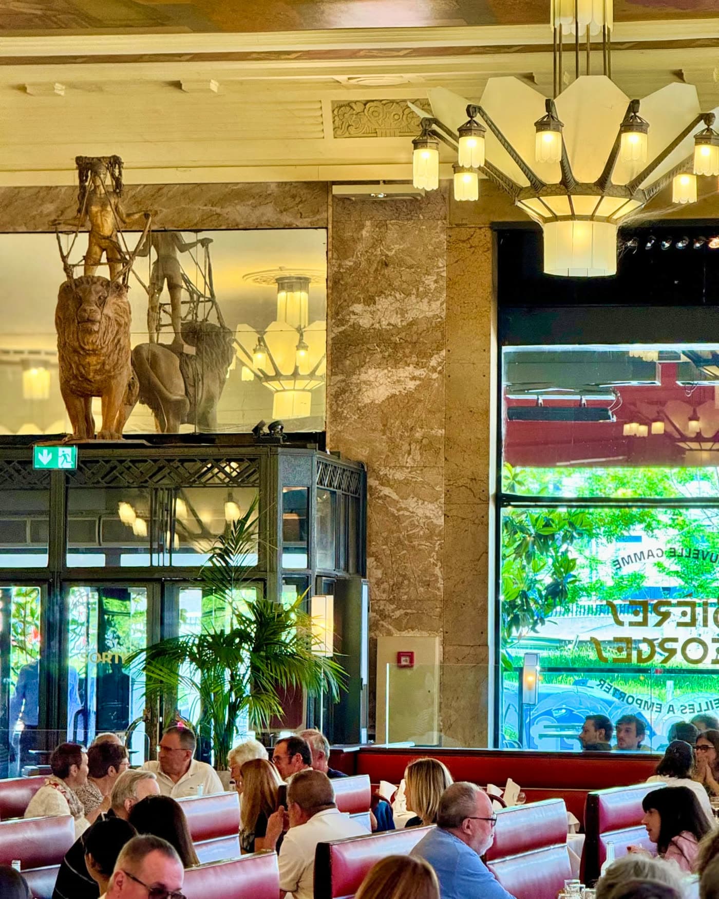 Vue large de la salle avec lustres Art déco, statues de lions dorés et clients attablés — Brasserie Georges