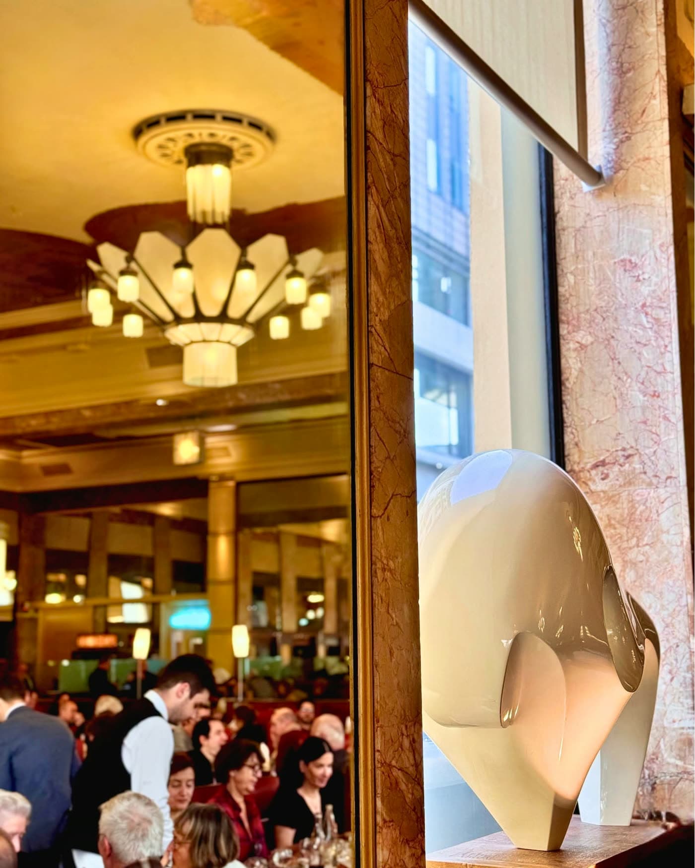Reflet dans miroir du plafond à lustres avec sculpture décorative en premier plan — Brasserie Georges