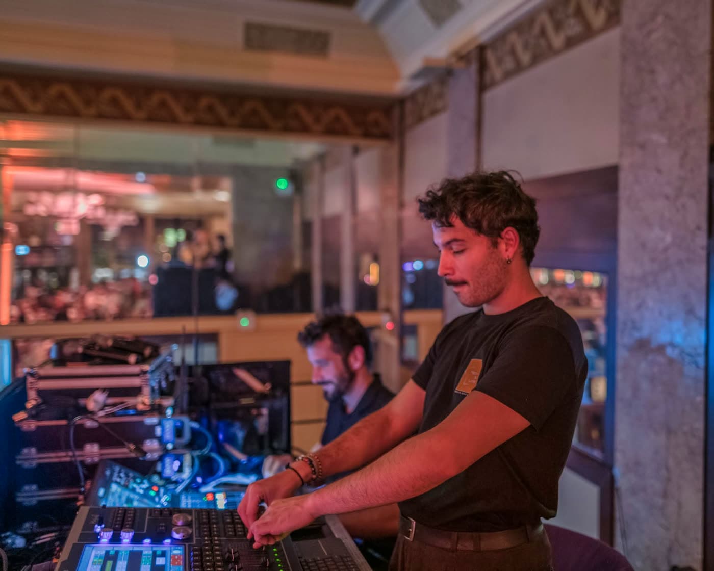 Technicien son manipule une table de mixage, éclairage bleu, ambiance concert — Brasserie Georges