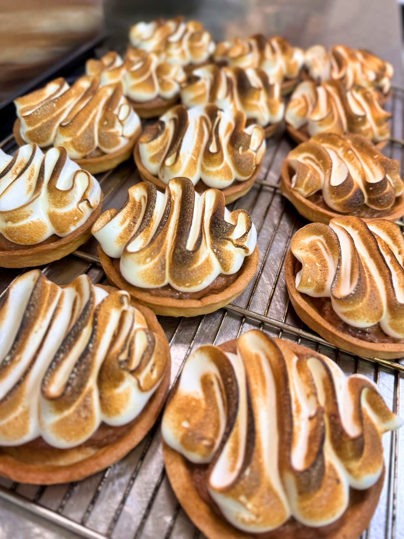 Tartelettes au citron meringuées, meringue torchée en vagues sur grille de cuisine — Brasserie Georges