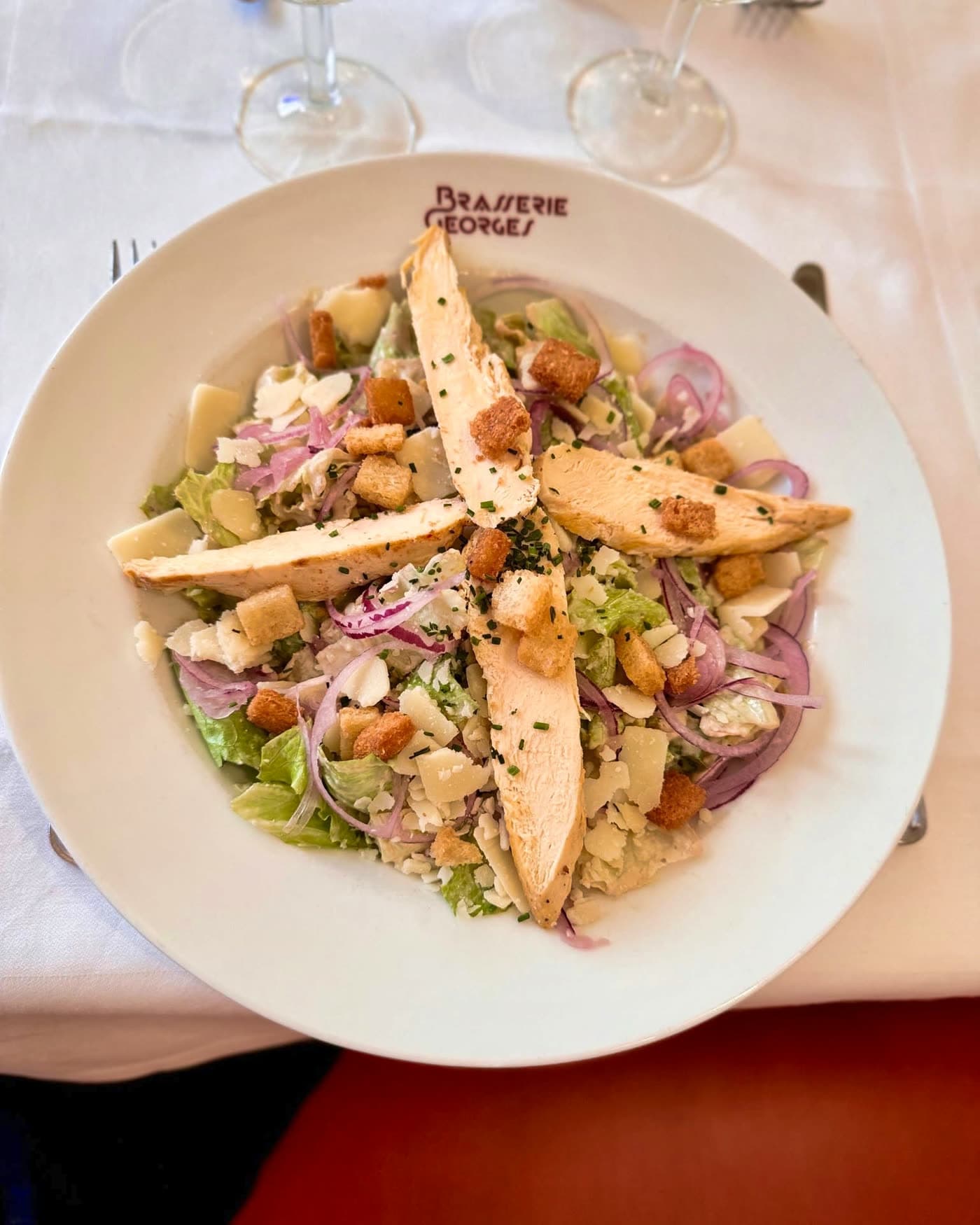 Salade César vue de dessus sur assiette siglée Brasserie Georges
