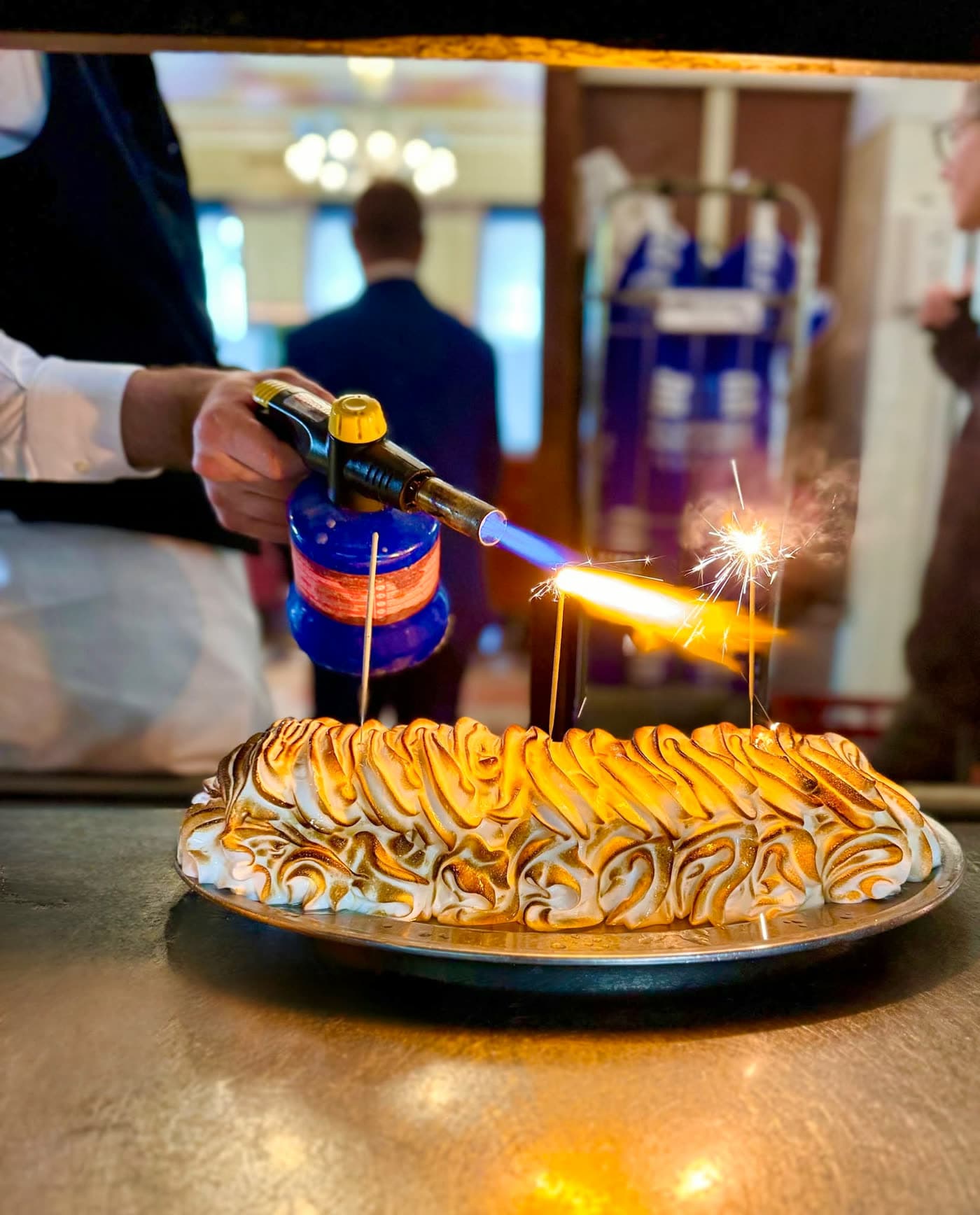 Omelette norvégienne flambée au chalumeau avec étincelles sur assiette — Brasserie Georges