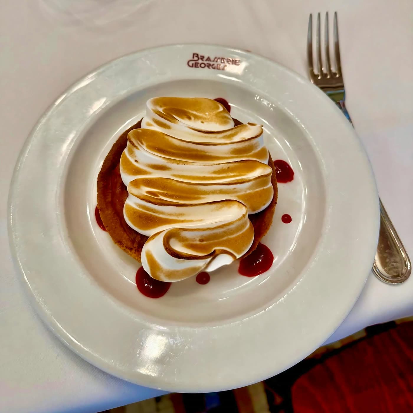 Gros plan meringue tourbillonnée d'une omelette norvégienne sur assiette siglée — Brasserie Georges