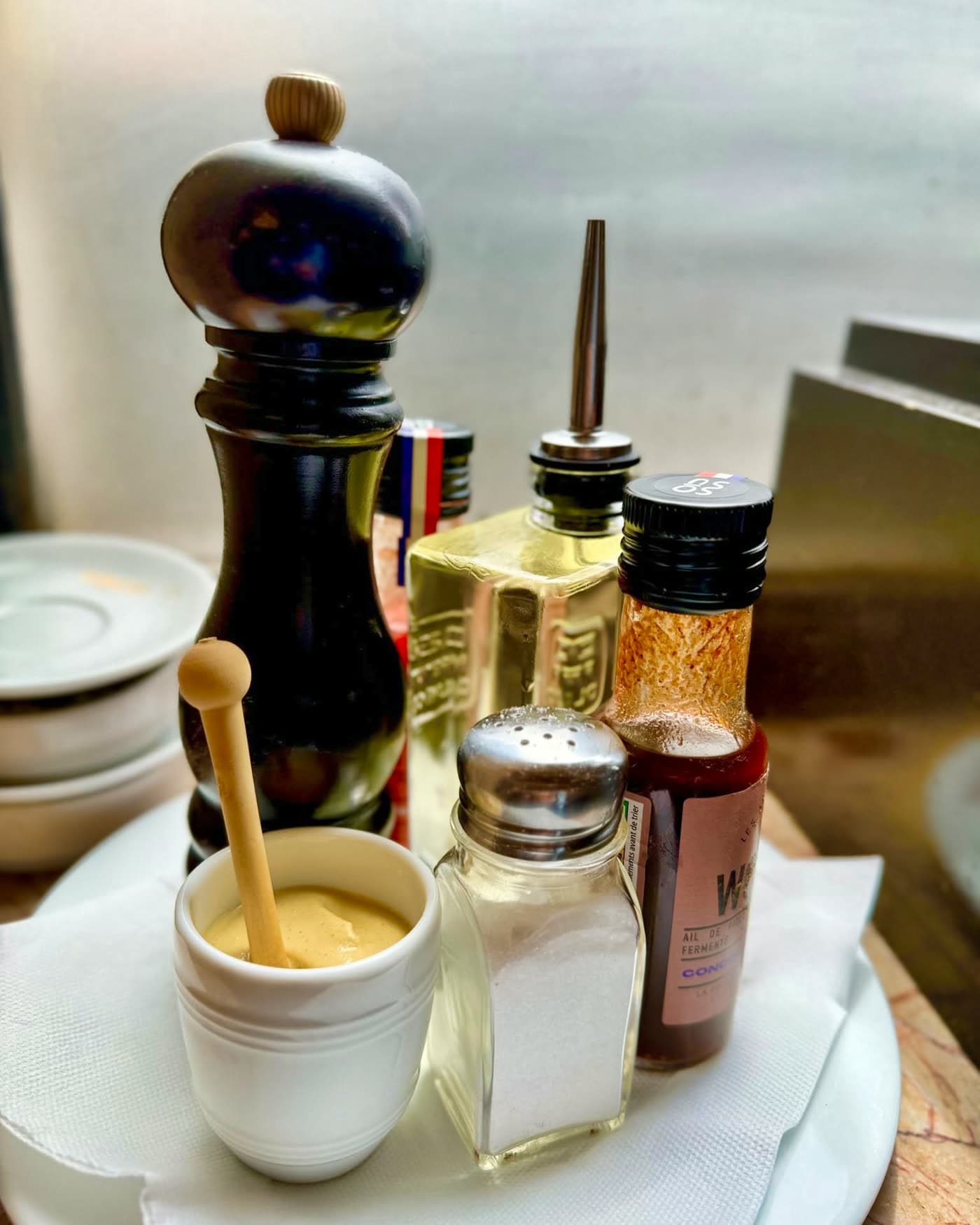 Nature morte de condiments de table : moutarde, poivrier, sel, sauce — Brasserie Georges