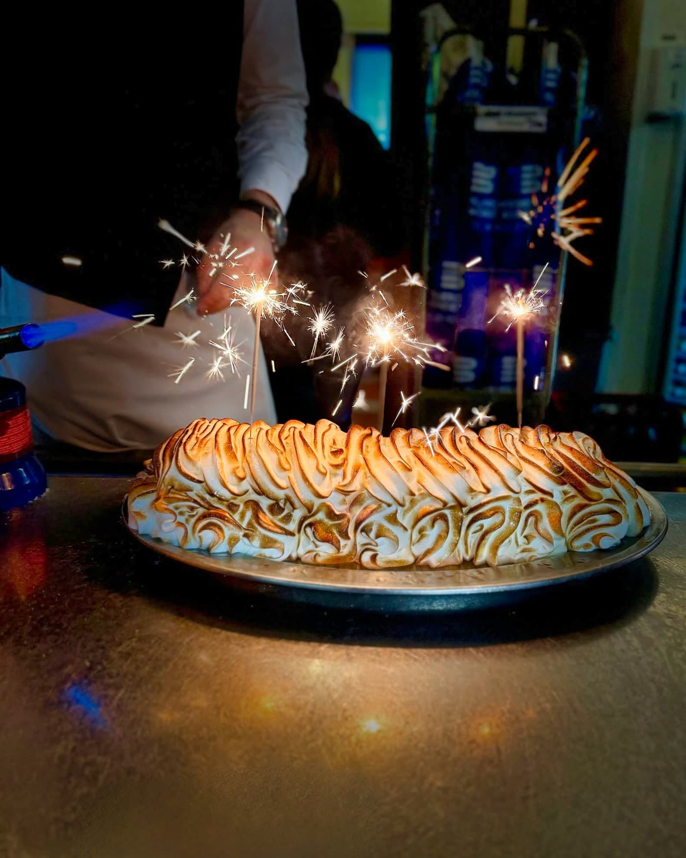 Omelette norvégienne décorée de cierges magiques allumés dans ambiance sombre — Brasserie Georges