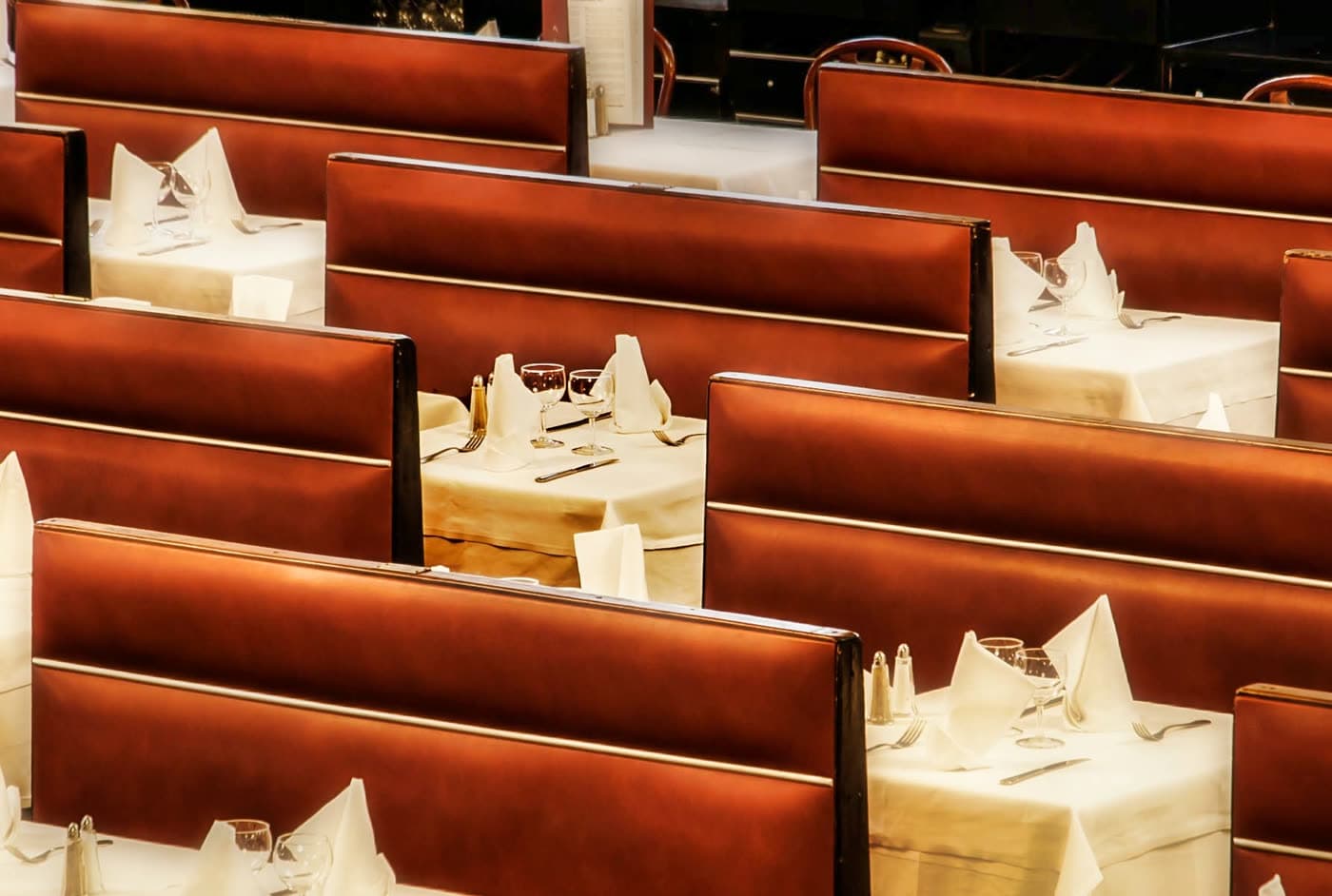 Banquettes bordeaux vues en enfilade avec tables dressées, angle plongeant — Brasserie Georges