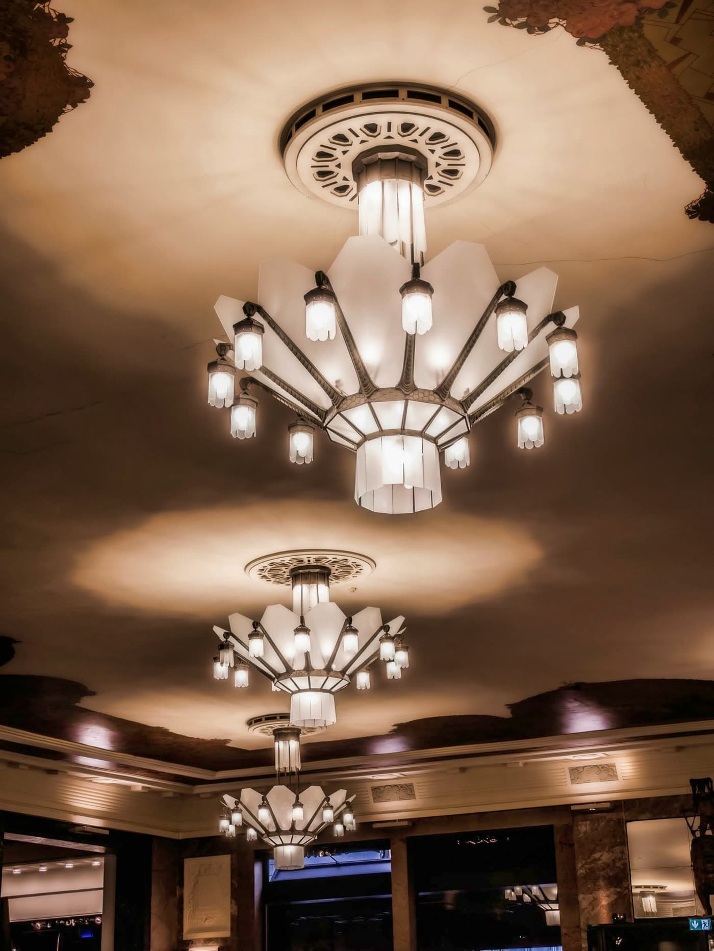 Gros plan des lustres Art déco en forme d'éventail au plafond doré — Brasserie Georges