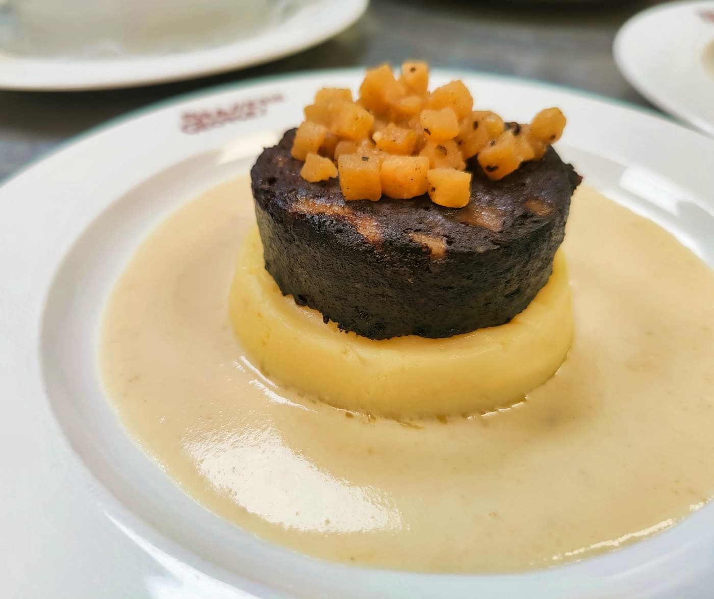 Boudin noir sur purée avec dés de fruits et sauce crème — Brasserie Georges