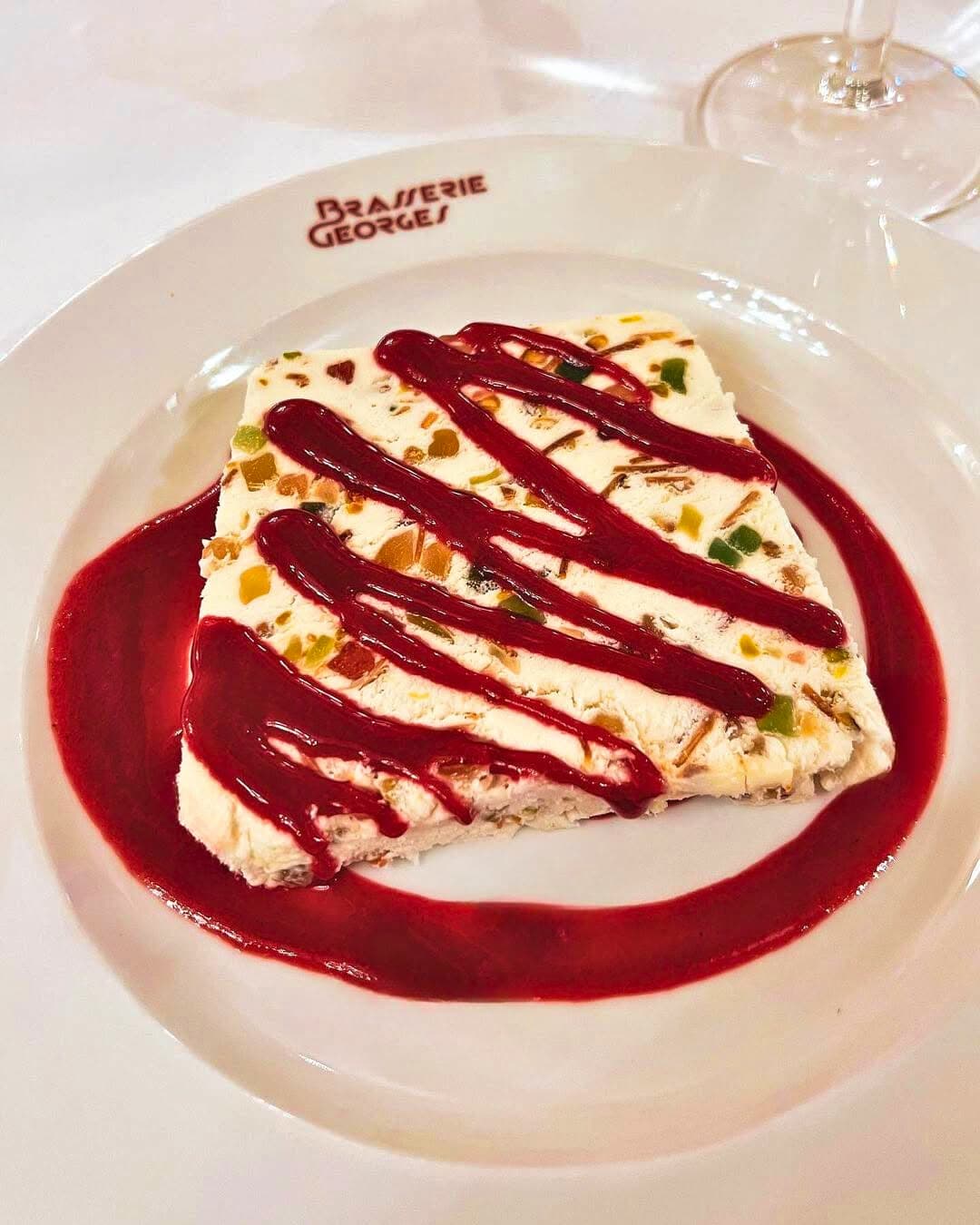 Nougat glacé aux fruits confits nappé de coulis de fruits rouges — Brasserie Georges