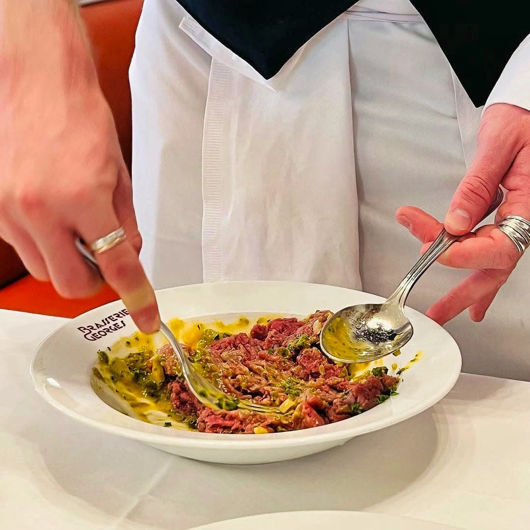 Serveur dresse un tartare de bœuf à la cuillère, gros plan mains — Brasserie Georges