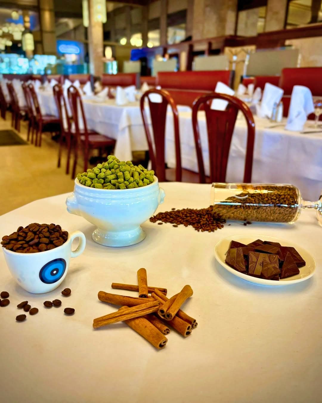 Ingrédients pour cocktails/desserts : fèves de cacao, pistaches, cannelle sur table dressée — Brasserie Georges