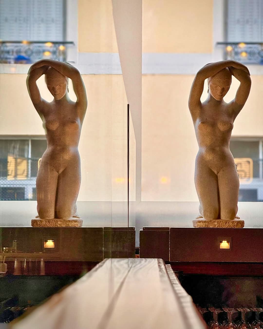 Deux statuettes féminines Art déco en terre cuite se reflétant dans une vitre — Brasserie Georges