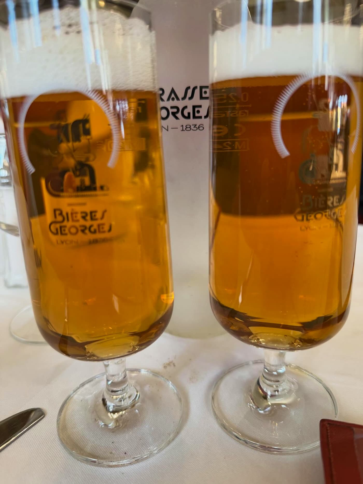 Deux verres de bière Bières Georges pression sur nappe blanche — Brasserie Georges