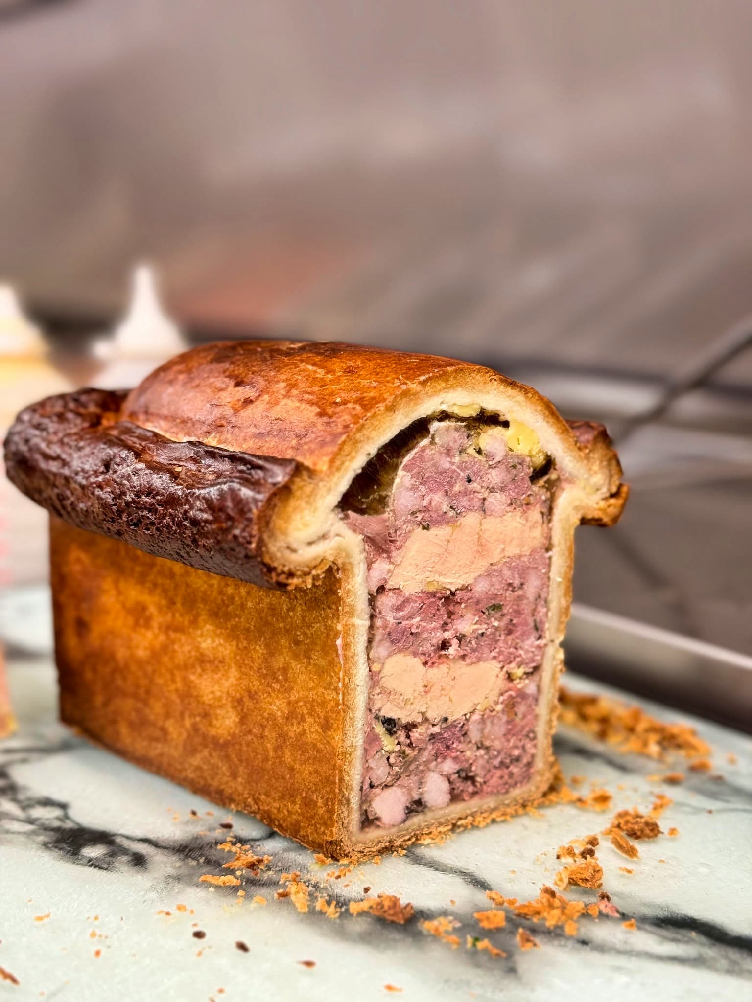 Pâté en croûte royal au veau et foie gras, tranché sur son marbre