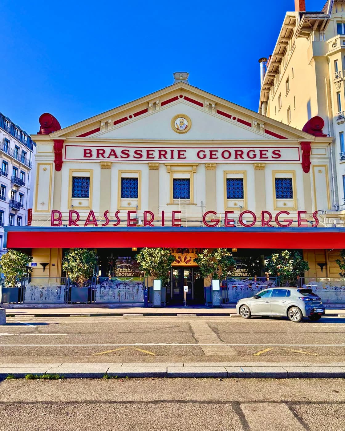 La façade de la Brasserie Georges de face, sous un ciel bleu