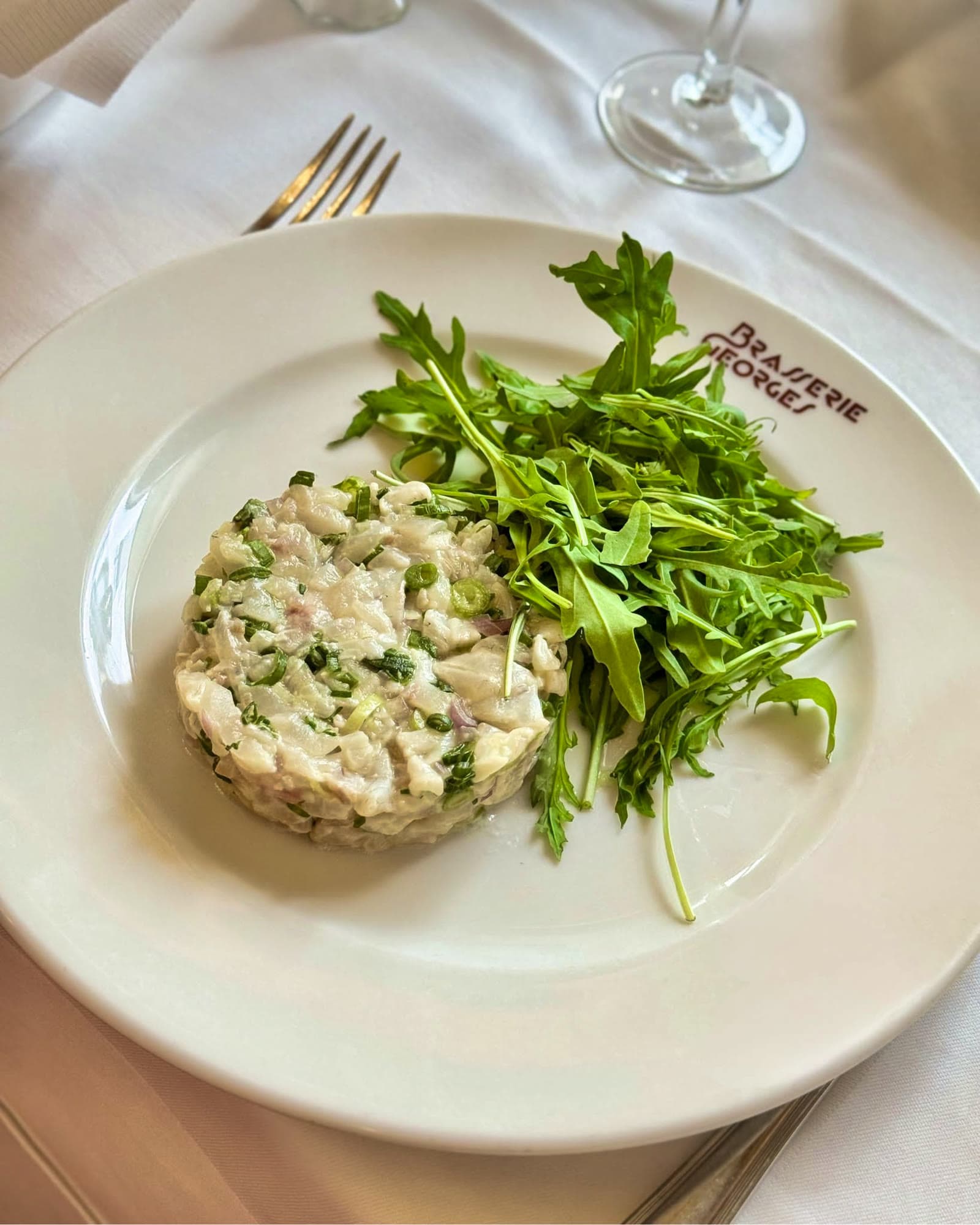 Tartare de bar à la coriandre fraîche et cébette, servi avec sa roquette