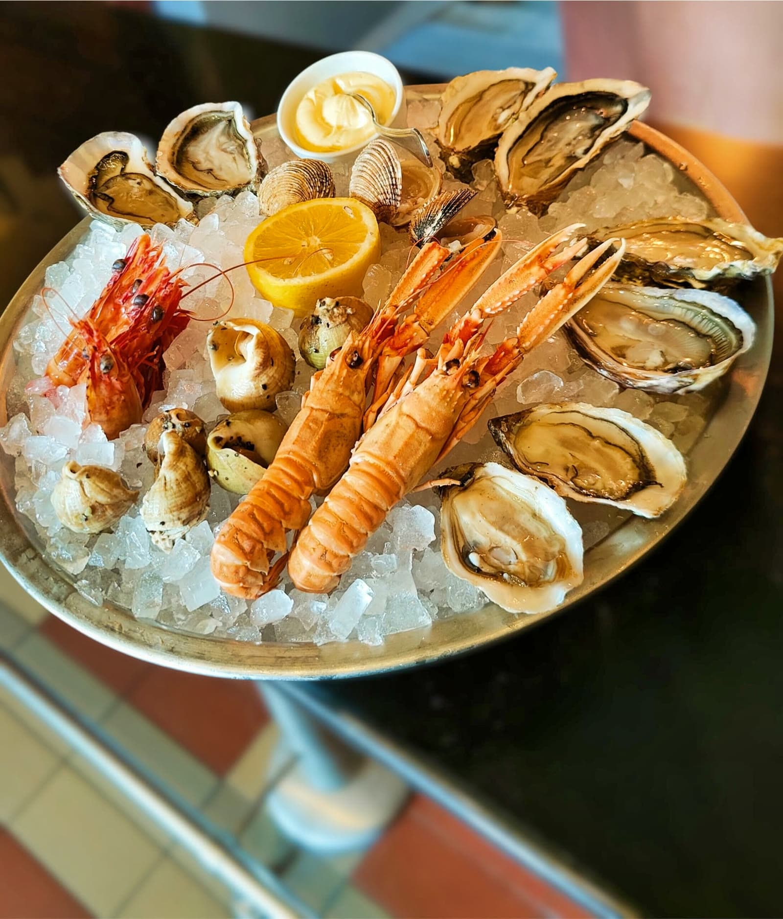 Plateau de fruits de mer dressé sur glace : huîtres, langoustines, palourdes et bulots