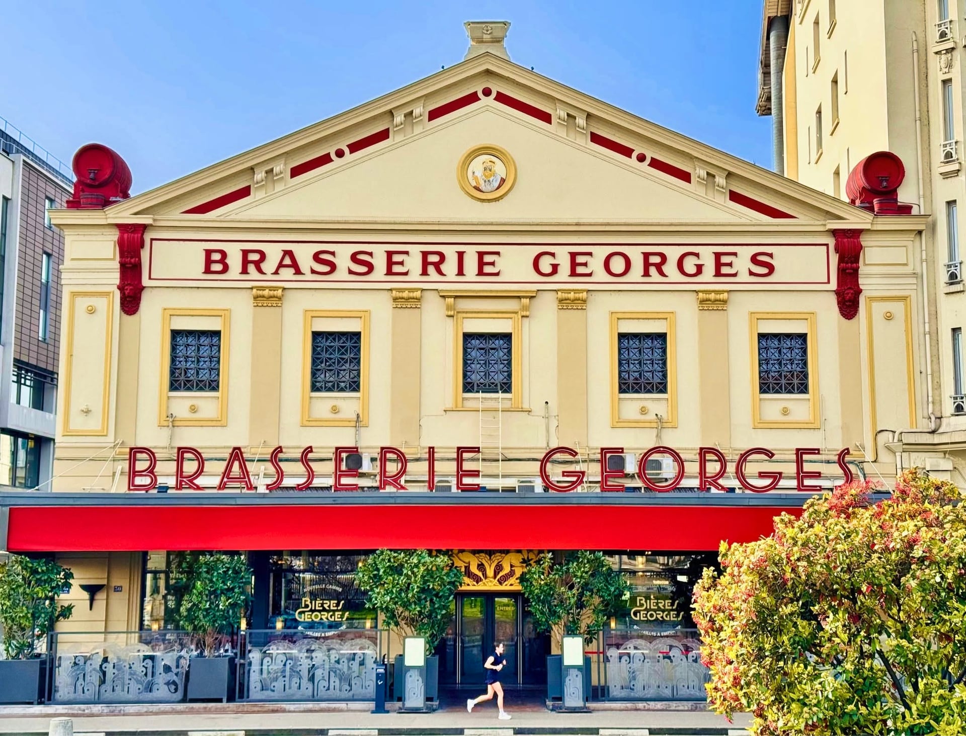 La façade de la Brasserie Georges vue de face, son fronton, son médaillon et son enseigne rouge