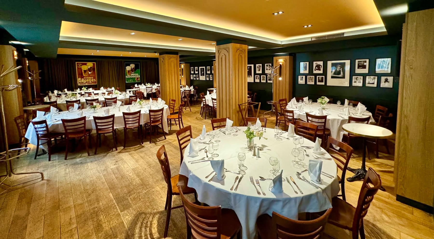 Un salon privé de la Brasserie Georges, ses murs verts et ses tables rondes dressées