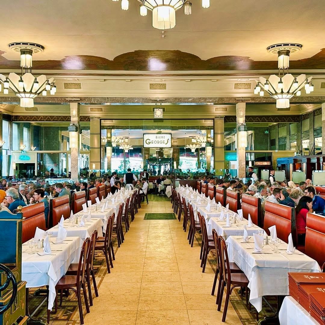 La grande salle de la Brasserie Georges vue en enfilade, ses tables dressées et ses lustres Art Déco